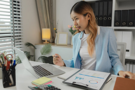 a businesswoman is working in her office, an entrepreneur works on new project in a workplace, a female employee is working in big company in her nice office, strategy and ideaの写真素材