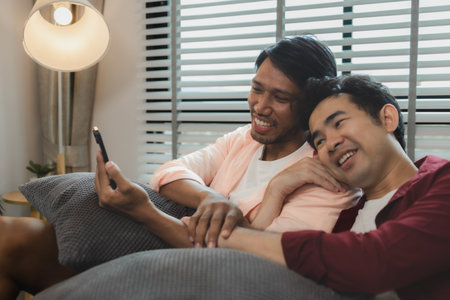 a male couple is spending time together happily in their living room, two handsome guys have a beautiful friendship for a long time, this male couple looks cute together, romanticの写真素材