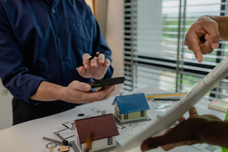 an architect and an engineer are discussing about big projects that they have to take responsibility for together, engineer and his assistant are meeting about the first draft of blueprintの写真素材