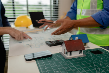 an architect and an engineer are discussing about big projects that they have to take responsibility for together, engineer and his assistant are meeting about the first draft of blueprintの写真素材