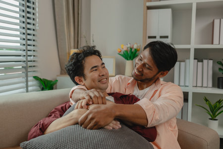two beautiful guys spend their time together in the living room as a couple, romantic relationship...