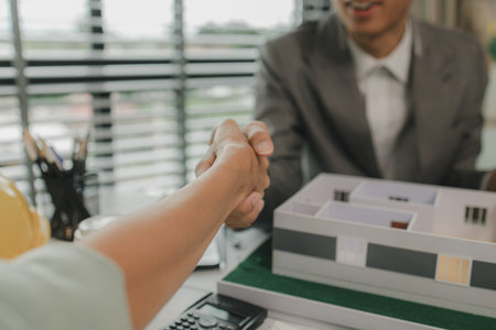 architect and engineer are shaking hand after successfully completing the work, an architect is consulting with an engineer about designing a house structure to meet the client's needsの写真素材