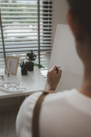 an artist is sitting in his own painting studio with his various painting tools, which is canvas, palette, watercolors, oils, poster colors , artistic, painter, colours, creativity, skillsの写真素材