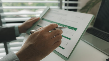 a businessman is in his private office and working with a lot of paperwork, a senior executive of marketing company is checking income report of this year, analyzing documentの写真素材