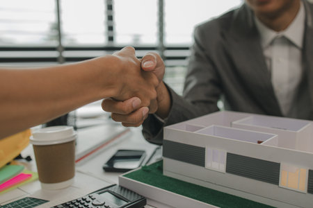 architect and engineer are shaking hand after successfully completing the work, an architect is consulting with an engineer about designing a house structure to meet the client's needsの写真素材