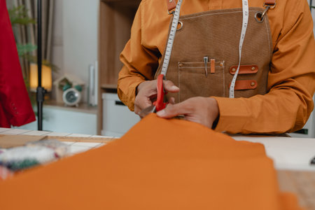 designer shop owner is working in his studio, use a lot of fabric to make clothes, design fashionable clothes for customer, sewing is an important tool for designer.の写真素材