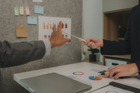 two businessmen are having a meeting and discussing the content of an important paperwork, there is...
