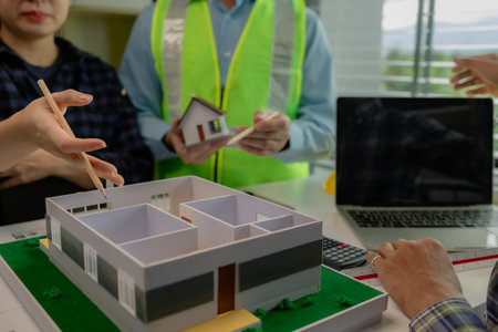 Engineers and contractors collaborate to solve problems that arise in design and construction, architects meets in the office to analyze the design structure to ensure it meets the client's wants.の写真素材