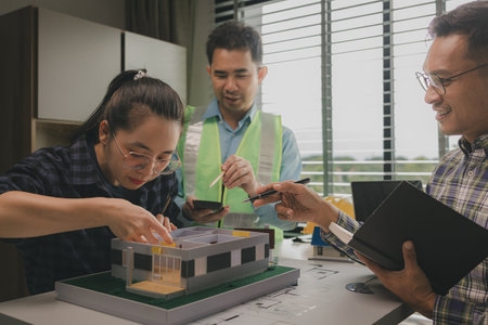 A team of engineers meets in the office to analyze the design structure to ensure it meets the...