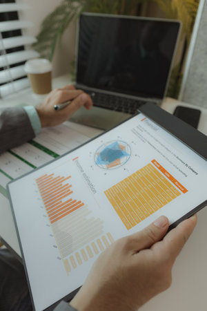 a businessman is in his private office and working with a lot of paperwork, a senior executive of marketing company is checking income report of this year, analyzing documentの写真素材