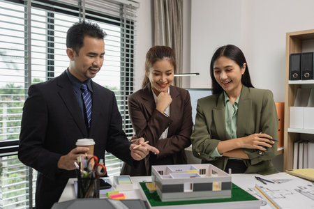 Architects work with engineers and contractors in the office to check the accuracy of the first...