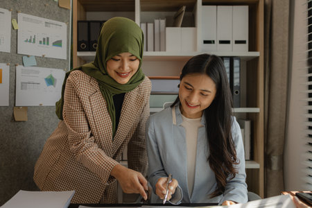 A very talented Muslim businesswoman wears the hijab to show her faith. A company with many businesspeople and employees of different faiths and religions work together peacefully.の写真素材