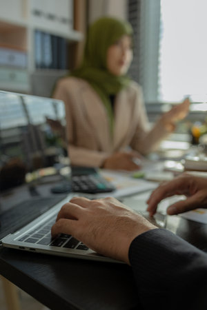 group of businessmen are discussing in an office. businessmen of different culture are meeting to make products that are appropriate and religiously correct. A businesswoman is wearing a hijab.の写真素材