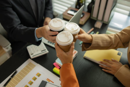 a group of businessman is meeting in the office in the morning with their coffee, colleagues sit together having some coffee in the workplace, businesspeople discussion about their new projectの写真素材