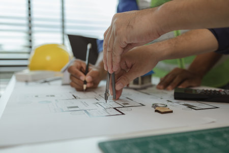 an architect and an engineer are discussing about big projects that they have to take responsibility for together, engineer and his assistant are meeting about the first draft of blueprintの写真素材