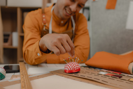 a fashion designer dis taking a break in his sewing studio after working all morning, a tailor is...