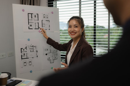 an architect is working in the office with his team, blueprint on the desk, contractor working with...