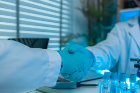 two scientists show their appreciation by shaking hands or high-fiving each other after their long-standing scientific research has been successful, the two researchers showed signs of joy after workの写真素材