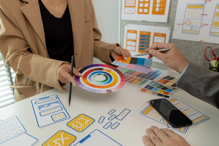 Digital product designers exchange ideas in their offices about how to design a website that meets the needs of today's users, who focus on ease of use and beautiful colors.の写真素材