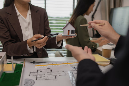 an architect is working in the office with his team, blueprint on the desk, contractor working with...