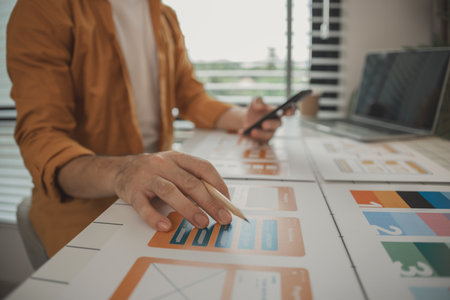 A web developer, as a User Experience and User Interface Officer, is designing beautiful and easy-to-use digital products that create a positive emotional and visual experience for users.の写真素材