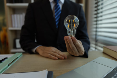 Businessman dressed in a suit is working in an office at a company. A senior executive is in a private office and doing many things. The atmosphere of a private office is calm and peaceful.の写真素材
