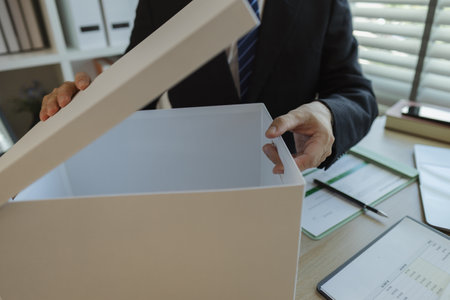 An office worker is putting important documents in boxes to prevent loss. A businessman is putting important work documents in a neat place. Documents and reports.の写真素材