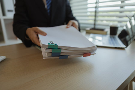 Businessman dressed in a suit is working in an office at a company. A senior executive is in a private office and doing many things. The atmosphere of a private office is calm and peaceful.の写真素材