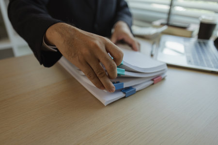 Businessman dressed in a suit is working in an office at a company. A senior executive is in a private office and doing many things. The atmosphere of a private office is calm and peaceful.の写真素材