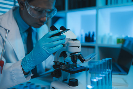 scientist working on scientific equipment in modern laboratory doing research on chemicals and...