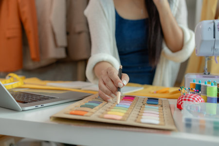 beautiful young lady tailor at work, beautiful female designer at design studio, crop view of fashion designer at work, woman in tailor workshop, clothing designer in workshop.の写真素材