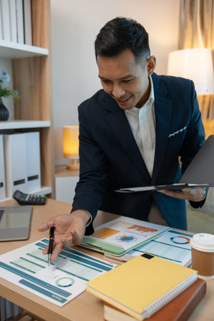 Image of handsome businessman is working in office, cheerful businessman entrepreneur professional working while sitting at office desk, accountant, marketing, employee is working alone in the officeの写真素材