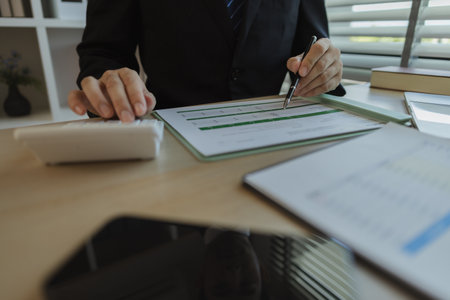 Businessman dressed in a suit is working in an office at a company. A senior executive is in a private office and doing many things. The atmosphere of a private office is calm and peaceful.の写真素材
