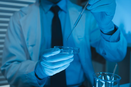 scientist working on scientific equipment in modern laboratory doing research on chemicals and bacteriaの写真素材