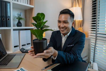 CEO of green business eco company holding plant, Ecology collaboration development ecosystem organization in greenery company partnership concept, he works in sustainable businessの写真素材