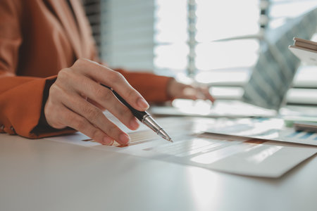 employees sit in an office with a pile of documents that need to be completed before work ends, entrepreneurs are planning their work to prepare for presentation to investorsの写真素材