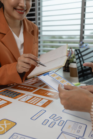 the development team is consulting on the design of the website UX UI, they are working on project of ux ui, interface, innovation of ux ui, develop team are discussing about their projectの写真素材