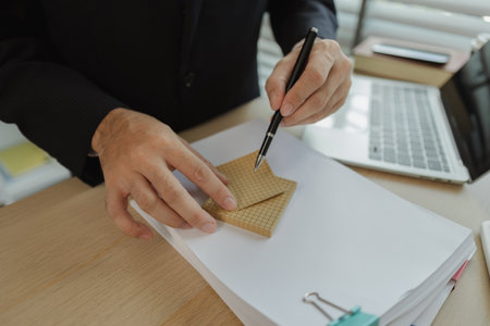 A businessman is planning a strategy to work efficiently and have the most positive impact on the company. An executive of a company is organizing ideas into a concrete form for easy understanding.の写真素材