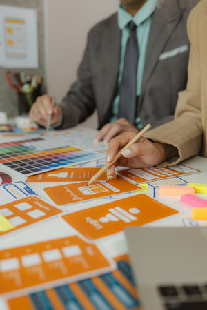 The web design team is consulting to exchange ideas on how to develop digital products, A team of web developers discusses how to best organize a website layout.の写真素材