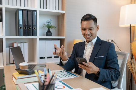 a businessman is talking on the phone with his colleague, a man is working in the office at company of accountant, an employee is in his private officeの写真素材
