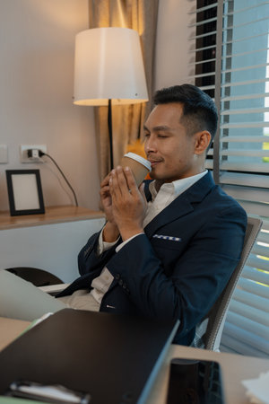 businessman in office relaxing in the office, calm businessman sit relax in his private office workplace take a break, happy relaxed young, man, Asian businessman is relaxing after finishing workの写真素材
