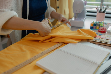 beautiful young lady tailor at work, beautiful female designer at design studio, crop view of fashion designer at work, woman in tailor workshop, clothing designer in workshop.の写真素材