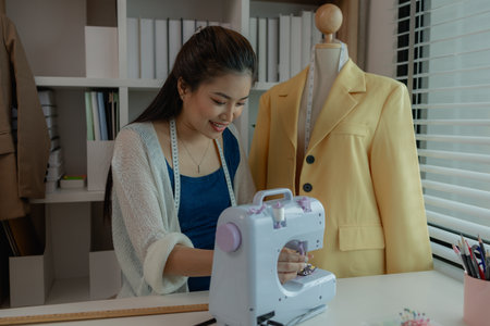 beautiful young lady tailor at work, beautiful female designer at design studio, crop view of fashion designer at work, woman in tailor workshop, clothing designer in workshop.の写真素材