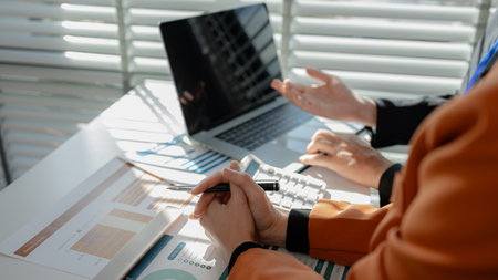 working atmosphere in an office during the day, an employee is sitting at his desk working with his...