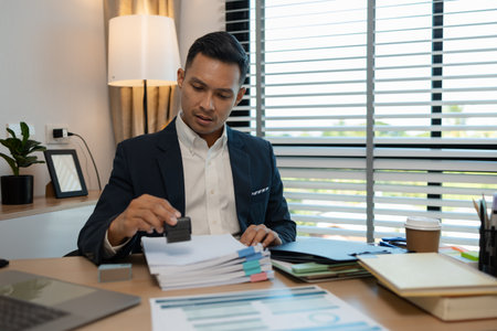 stamped the document to approve, businessman professional working while sitting at office desk, accountant, marketing, employee is working alone in the office, approving report,の写真素材