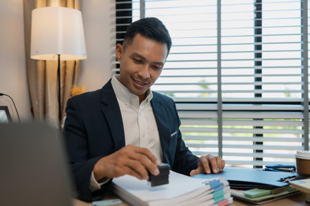 stamped the document to approve, businessman professional working while sitting at office desk, accountant, marketing, employee is working alone in the office, approving report,の写真素材
