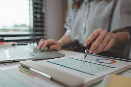 businesswoman working on laptop in her studio, businessperson working on a digital tablet and laptop in an office, busy professional executive leader working on business finances analysisの写真素材