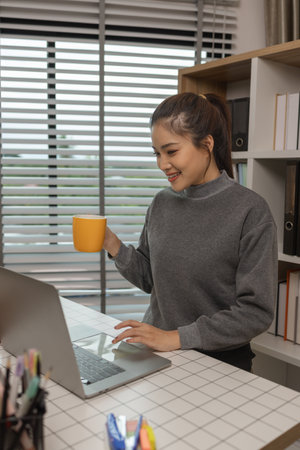 happy woman working on laptop at home office, entrepreneur using laptop at home office, mature businesswoman working from home, beautiful company owner working during isolation periodの写真素材
