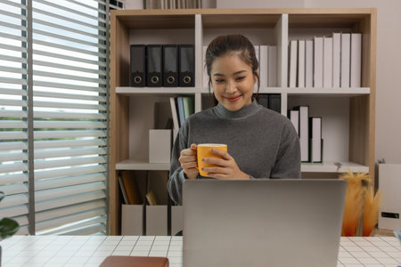 happy woman working on laptop at home office, entrepreneur using laptop at home office, mature businesswoman working from home, beautiful company owner working during isolation periodの写真素材