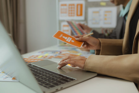 The web design team is consulting to exchange ideas on how to develop digital products, A team of web developers discusses how to best organize a website layout.の写真素材